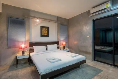 a bedroom with a bed with two tables and two lamps at Amarin Hotel Patong in Patong Beach