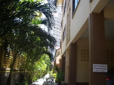 a street with palm trees and a building with a no parking sign at Smile Home in Patong Beach