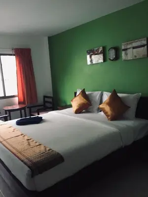a bedroom with a large bed with a green wall at Smile Home in Patong Beach