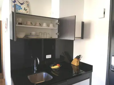 a kitchen with a sink and a black counter top at The Deck Patong by VIP in Patong Beach