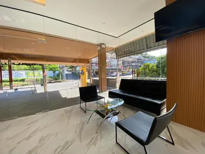 a living room with a black couch and a glass table at Mala Hotel in Kata Beach