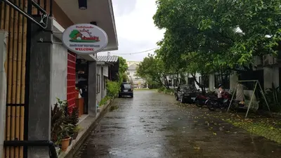 a wet street with a sign on the side of a building at Baan Nat The Village in Phuket Town