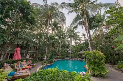 a group of people sitting around a pool at a resort at The Viridian Resort Patong in Patong Beach
