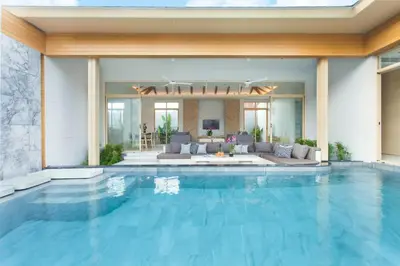 a swimming pool in a house with a living room at Himmapana Villas - SHA Extra Plus in Kamala Beach