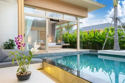 a house with a swimming pool in front of a house at Himmapana Villas - SHA Extra Plus in Kamala Beach