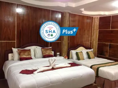 a hotel room with two beds with a woman laying on them at Ruan Mai Naiyang Beach Resort in Nai Yang Beach