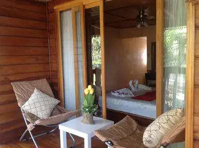 a room with a bed and a table and chairs at Ruan Mai Naiyang Beach Resort in Nai Yang Beach