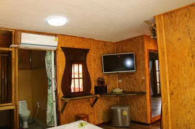 a room with a tv on the wall of a house at Ruan Mai Naiyang Beach Resort in Nai Yang Beach