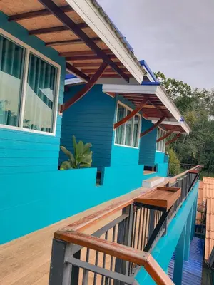a blue house with a wooden deck at Ban Tidlay - SHA in Ko Yao Noi