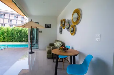 a living room with a table and chairs and a pool at Good Night Pool Villa Phuket - SHA Plus in Phuket Town