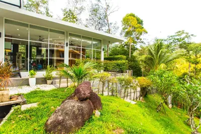 a house with a large rock in front of it at Great view in 81sqm top floor space in Kamala in Kamala Beach
