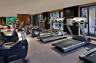 a gym with treadmills and elliptical machines at Radisson Resort and Suites Phuket in Kamala Beach