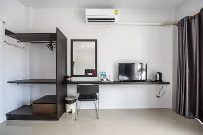 a room with a chair and a desk and a mirror at Mr.T Kamala Room in Kamala Beach