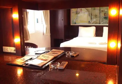 a hotel room with a bed and a desk with a book at Karon Cafe Inn in Karon Beach