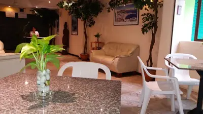 a living room with a table and chairs and a couch at Paradise Inn in Karon Beach