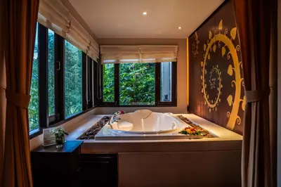 a large bath tub in a bathroom with windows at Suuko Villas in Chalong