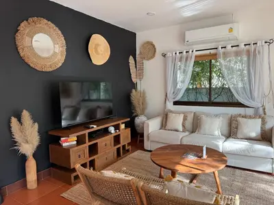 a living room with a couch and a table at Beachfront pool villa in Kamala Beach