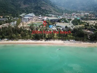 an aerial view of a beach with a town in the background at Beachfront pool villa in Kamala Beach