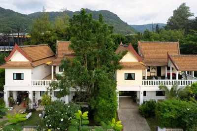 a row of houses with mountains in the background at Beachfront pool villa in Kamala Beach