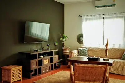 a living room with a couch and a table at Beachfront pool villa in Kamala Beach