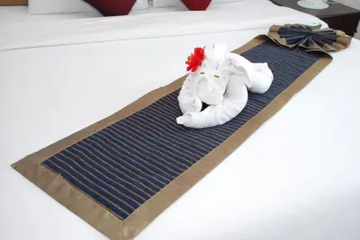 a hotel room with a towel animal on a bed at Phukamala Suite in Kamala Beach
