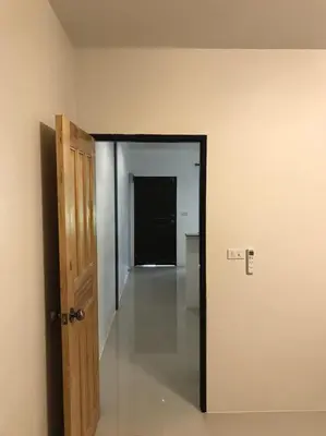 an empty room with a door and a hallway at Buncha Place in Bang Tao Beach