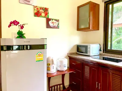 a kitchen with a white refrigerator and a microwave at Kannapat House in Ban Nong Thale