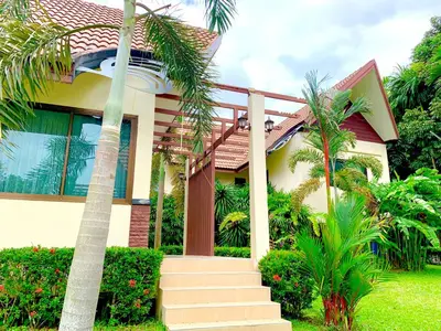 a house with palm trees in front of it at Kannapat House in Ban Nong Thale