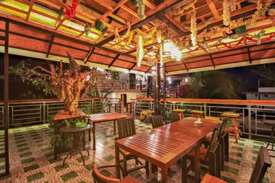 a restaurant with wooden tables and chairs and a ceiling at Happy Mountain Airport Resort in Nai Yang Beach