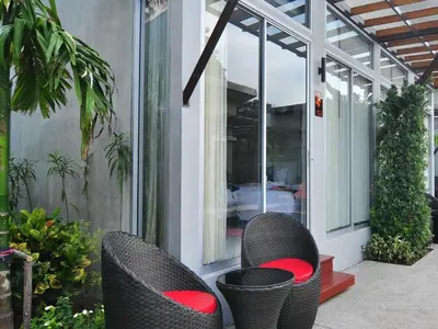 two wicker chairs sitting on the outside of a house at Phu NaNa Boutique Hotel - SHA Plus in Rawai Beach