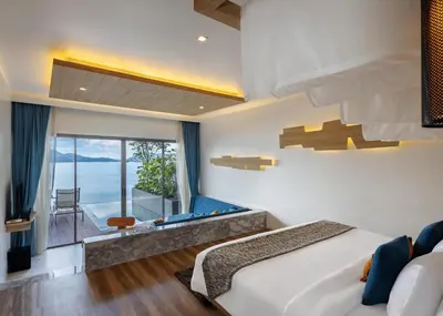 a bedroom with a large bed and a large window at Kalima Resort and Spa in Patong Beach