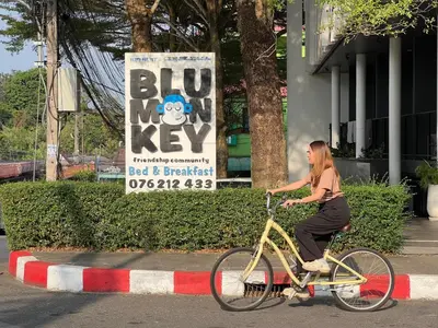 a woman riding a bike on a street at Blu Monkey Bed & Breakfast Phuket in Phuket Town
