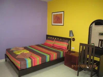 a bedroom with a bed and a table and a mirror at Popeye Guesthouse in Ao Nang Beach