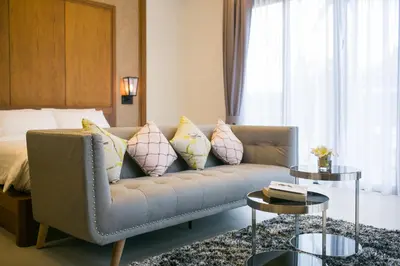 a living room with a couch with pillows and a bed at Villa Palavee (B1) in Ao Nang Beach