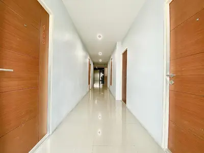 an empty corridor in a building with wooden doors at The Palms Residence - SHA Extra Plus in Phuket Town