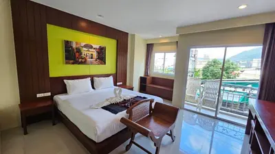a bedroom with a large bed and a balcony at Baan Sudarat Hotel in Patong Beach