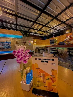 a counter with a vase of flowers and a sign at The Villa Residences Resort in Patong Beach
