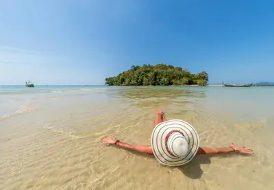 a person laying in the water on a beach at At Seacondo-1 Bedroom-A25 in Klong Muang Beach