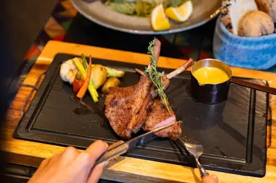 a person holding a plate of food with a steak at Hotel Indigo Phuket Patong by IHG in Patong Beach