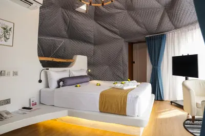 a bedroom with a large white bed and a tv at Le Resort and Villas in Rawai Beach