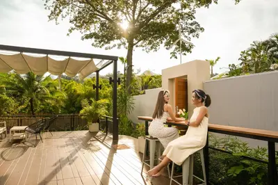 two women sitting at a table on a balcony at Le Resort and Villas in Rawai Beach