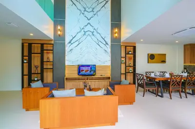 a living room with a table and a dining room at Le Resort and Villas in Rawai Beach