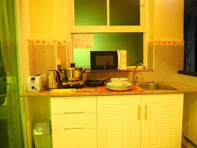 a kitchen with a sink and a microwave at Baan Rosa Bangtao Beach in Bang Tao Beach
