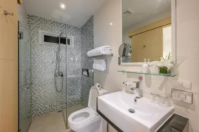 a bathroom with a sink and a toilet and a shower at The Beachfront Hotel Phuket in Rawai Beach