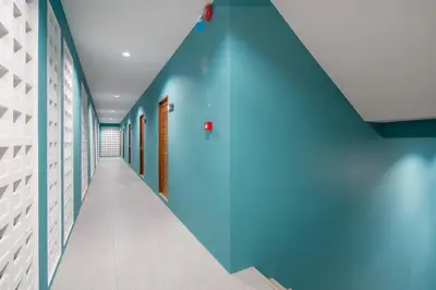 a hallway with a blue wall in a hospital at Peace Blue Naiharn Naturist Resort Phuket SHA Extra Plus in Rawai Beach