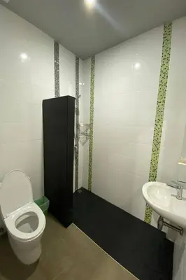a bathroom with a toilet and a sink at Tann Anda Resort in Thalang