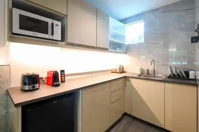 a kitchen with a sink and a microwave at CRAFT Resort & Villas, Phuket Town - scheduled shuttle to Phuket Old Town in Phuket Town