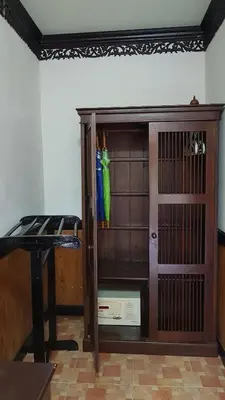 a wooden cabinet with a green bird sitting on top of it at Paradise Pearl Bungalows in Phi Phi Don