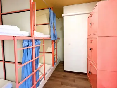 a room with bunk beds and a closet at Sleepy Station Hostel in Kata Beach