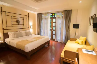 a bedroom with a bed and a table and a window at WOO Gallery & Boutique hotel in Phuket Town